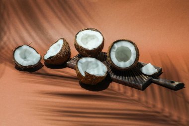 Taze hindistan cevizleri ve açık kahverengi arka planda tropikal palmiye tarafından dökülen gölge