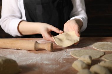 Khinkali yapıyorum. Mutfaktaki masada hamur şekillendiren kadın, yakın plan.