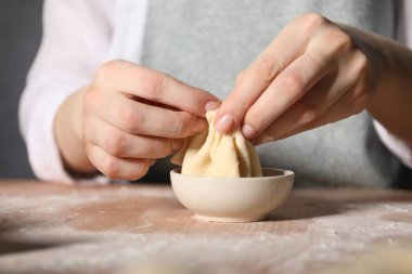 Mutfaktaki masada khinkali yapan kadın, yakın plan.