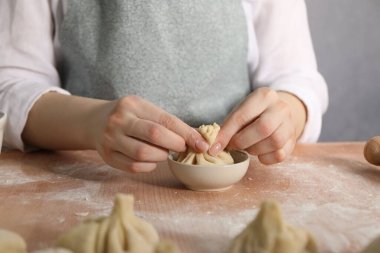 Mutfaktaki masada khinkali yapan kadın, yakın plan.