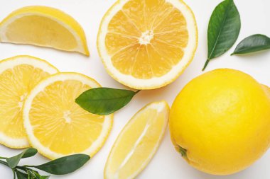 Taze limon ve yapraklar beyaz arka planda, düz yatıyordu