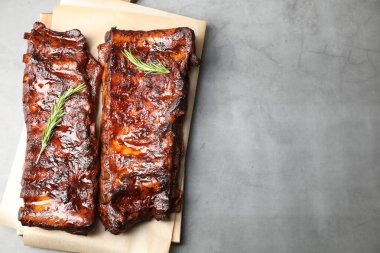 Açık gri masada biberiyeli domuz pirzolası servis ediliyor. Metin için boşluk