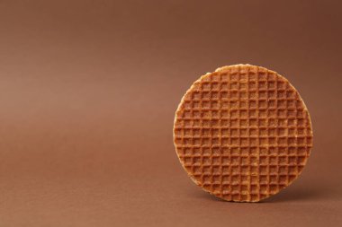 Kahverengi arka planda lezzetli yuvarlak bir waffle. Metin için boşluk