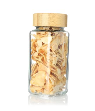 Baharat kavanozundaki kurutulmuş sarımsak taneleri beyaza izole edilmiş.