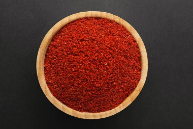 Siyah arka planda, kasede kırmızı biber tozu, üst manzara. Aromatik baharat