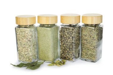 Beyaz kavanozlardaki farklı aromatik baharatlar.