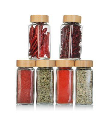 Beyaz kavanozlardaki farklı aromatik baharatlar.