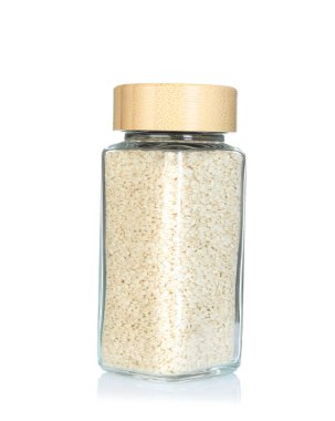 Baharat kavanozundaki susam tohumları beyaza izole edilmiş.