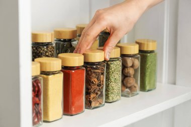 Kapalı mekanda kırmızı biber tozlu kavanoz alan kadın, yakın plan.