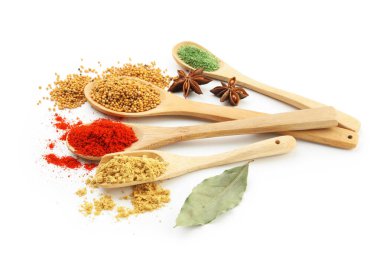 Beyaz kaşıklardaki farklı aromatik baharatlar.