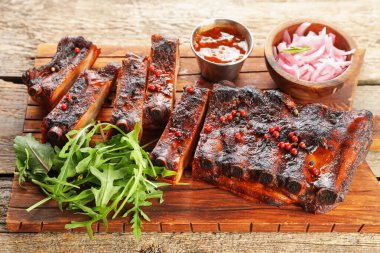 Lezzetli pirzola, soğan, sos ve roka.