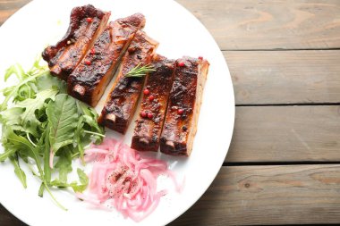 Lezzetli pirzola, soğan ve roka, ahşap masa, üst manzara. Metin için boşluk