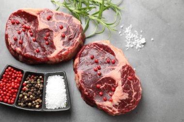 Çiğ et parçaları ve baharatlar gri dokulu masa üzerinde, düz yatıyordu.