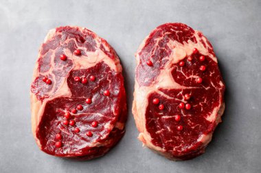 Çiğ et parçaları ve baharatlar gri dokulu masa üzerinde, düz yatıyordu.