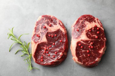 Çiğ et parçaları ve baharatlar gri dokulu masa üzerinde, düz yatıyordu.