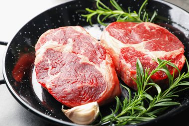 Yemek masasında çiğ et ve baharat parçaları, yakın plan.