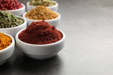 Gri masada farklı aromatik baharatlar, yakın plan. Metin için boşluk