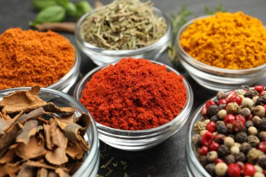 Gri masada farklı aromatik baharatlar, yakın plan.