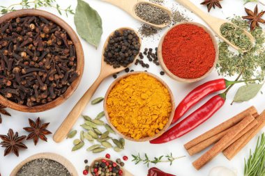 Beyaz arka planda farklı aromatik baharatlar, düz yatış