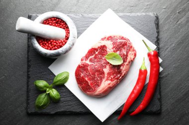 Siyah masada çiğ et ve baharat var.