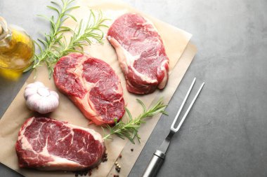 Çiğ et, baharat ve çatal parçaları gri masada, düz yerde. Metin için boşluk