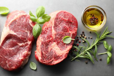 Çiğ et parçaları ve baharatlar gri masada, düz yatıyordu.