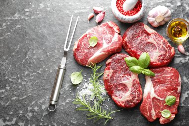 Çiğ et, baharat ve çatal. Koyu masada, düz yerde. Metin için boşluk