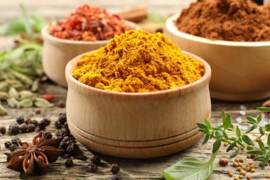 Ahşap masada farklı aromatik baharatlar, yakın plan.