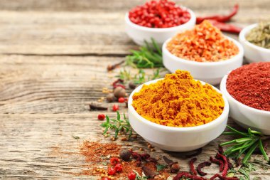 Ahşap masada farklı aromatik baharatlar, yakın plan. Metin için boşluk