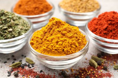 Açık gri masada farklı aromatik baharatlar, yakın plan.