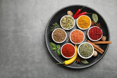 Gri masada farklı aromatik baharatlar, üst manzara. Metin için boşluk