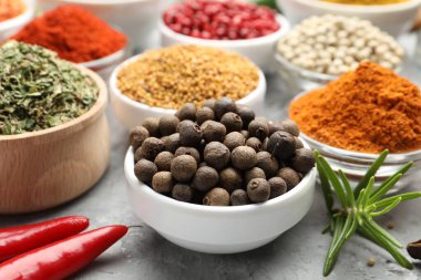 Gri masada farklı aromatik baharatlar, yakın plan.