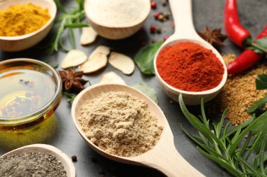 Gri masada farklı baharatlar ve yağ, yakın plan.