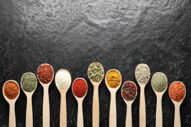 Siyah masadaki kaşıklarda bir sürü farklı baharat var. Metin için boşluk