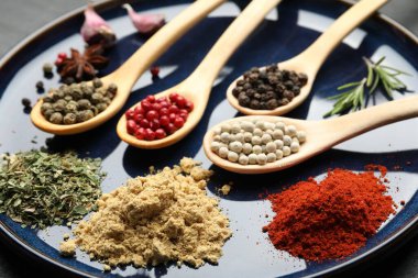 Tabaktaki kaşıklardaki farklı aromatik baharatlar, yakın plan.