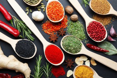 Siyah masadaki kaşıklardaki farklı aromatik baharatlar.