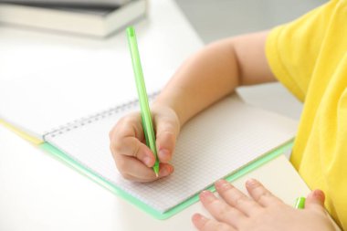 Küçük kız ev ödevlerini içeride yapıyor, yakın plan.