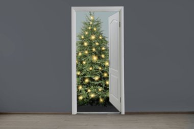 Kapının önünde şenlik ışıkları olan güzel bir Noel ağacı. Tatil sezonu