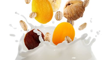 Süt, yulaf ezmesi ve beyaz arka planda kuru meyveler. Sağlıklı kahvaltı.