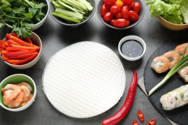 Pilav kağıtları ve farklı malzemeler koyu gri masada, düz yerde.