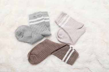 Beyaz sahte kürkte farklı yumuşak çoraplar, üst manzara.