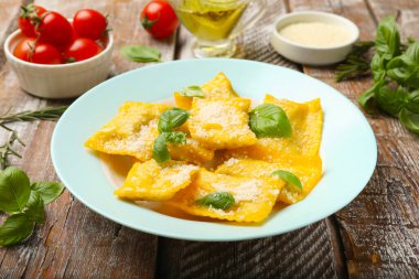 Tahta masada servis edilen peynirli ve fesleğenli lezzetli ravioli.