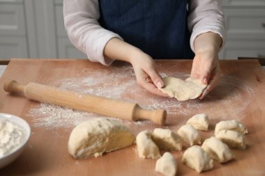 Khinkali yapıyorum. Mutfaktaki masada hamur şekillendiren kadın, yakın plan.