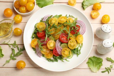 Beyaz ahşap masada sarı domatesli taze salata.
