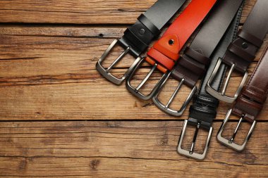 Tahta masanın üzerinde bir sürü farklı deri kemer vardı, düz yatıyordu. Metin için boşluk