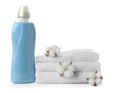 Bir şişe yumuşatıcı, pamuk çiçekleri ve beyaz üzerine izole edilmiş temiz havlular.