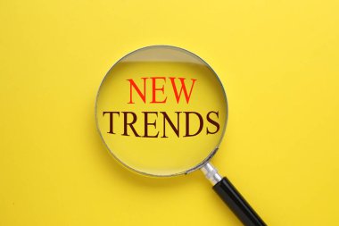 Yeni trendler. Sarı zemin üzerinde büyüteç, üst görünüm