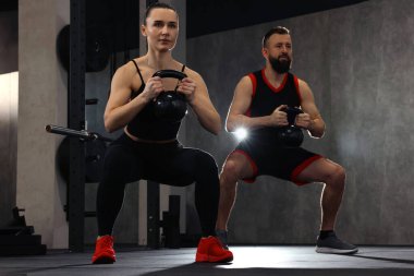 Spor salonunda çan sesleri eşliğinde atletik çift eğitimi.
