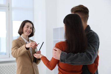 Emlakçı, evin yeni sahiplerine evin anahtarını veriyor.