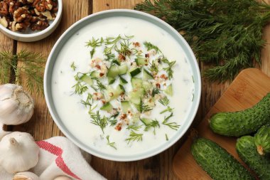 Tahta masadaki ürünlerin arasında salatalık çorbası, dereotlu fındıklı ve fındıklı.